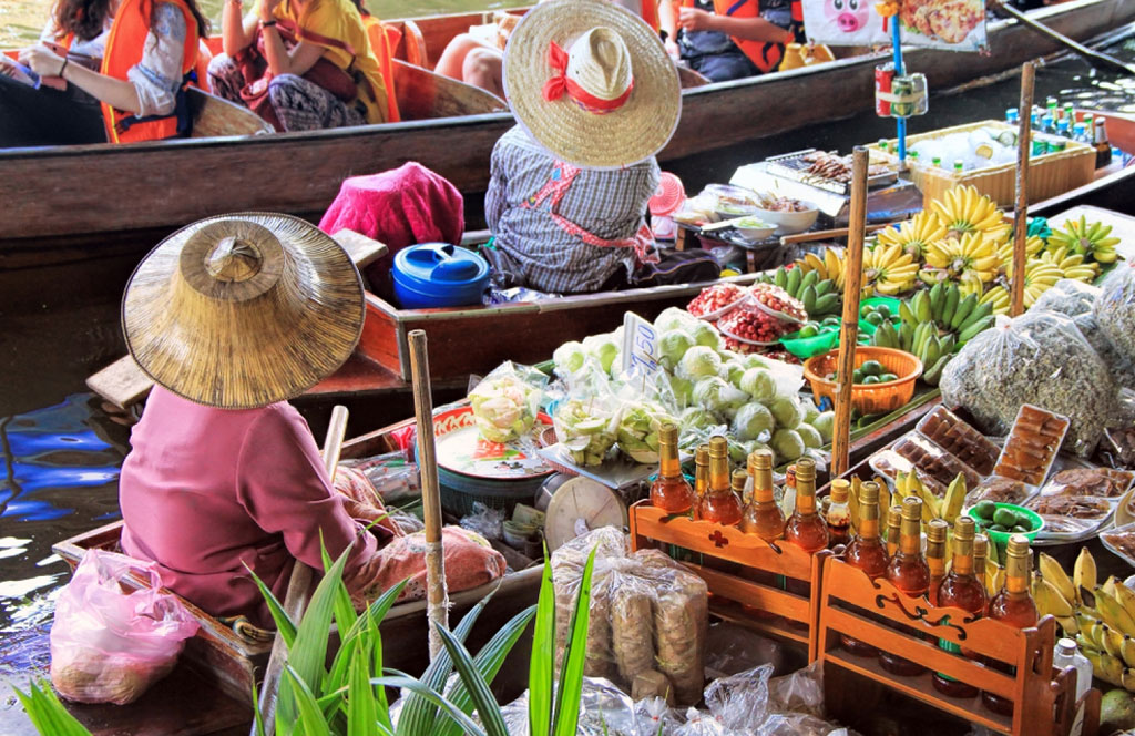 Turistas y vendedores tradicionales en el famoso mercado flotante de Tailandia, Damnoen Saduak.